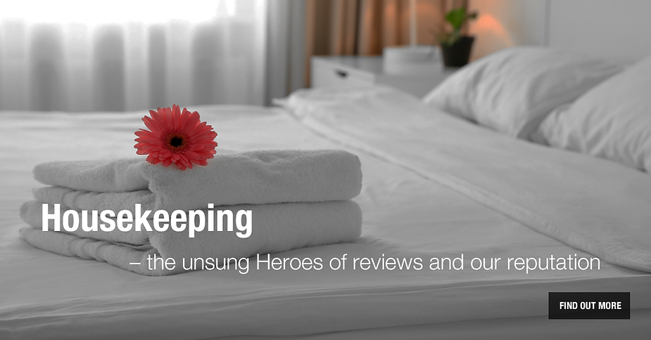 white bed with white towel and red flower on top